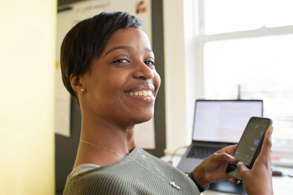 smiling woman using a chatbot on a smartphone