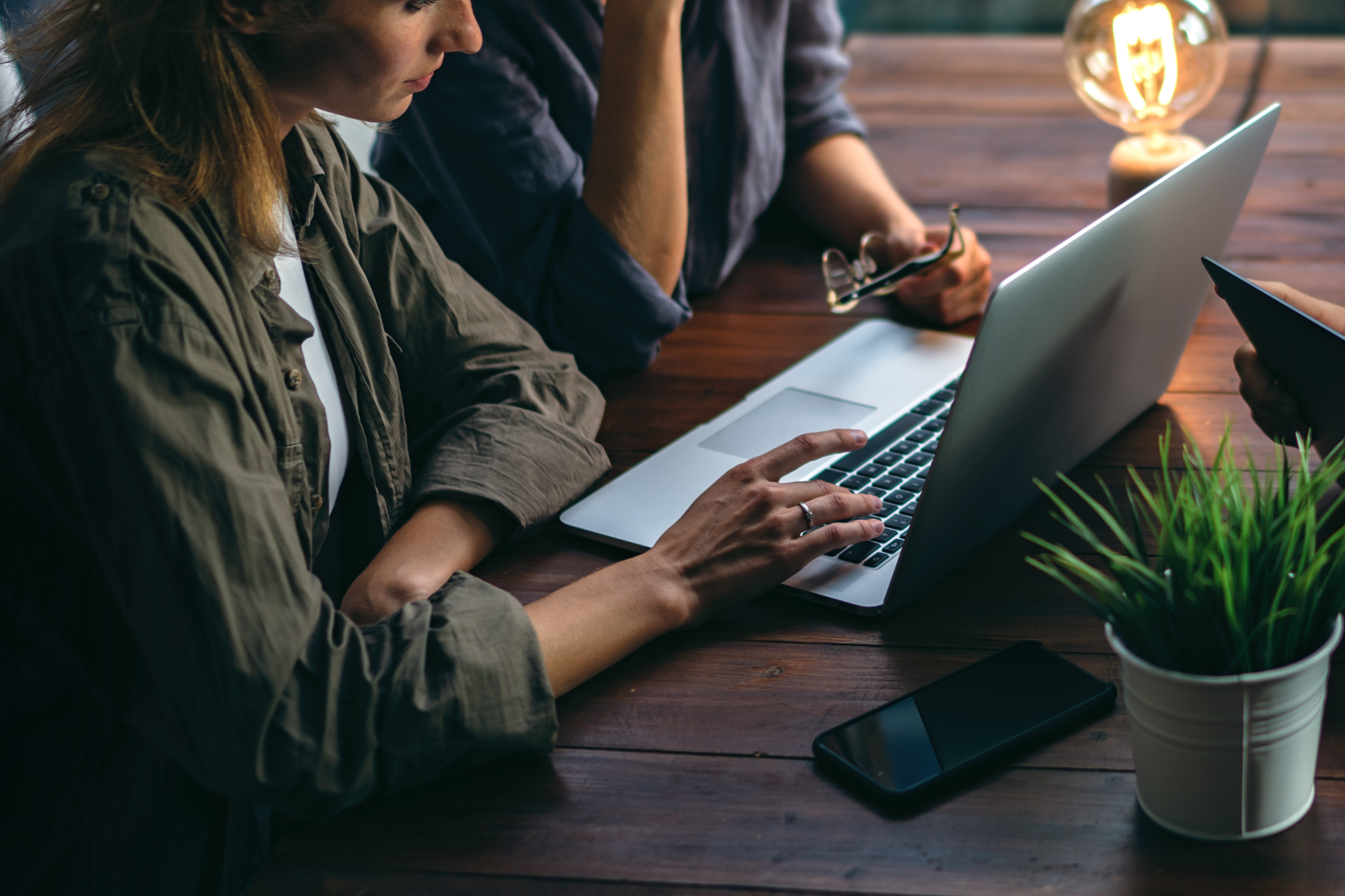 People at desk with a lightbulb and computer