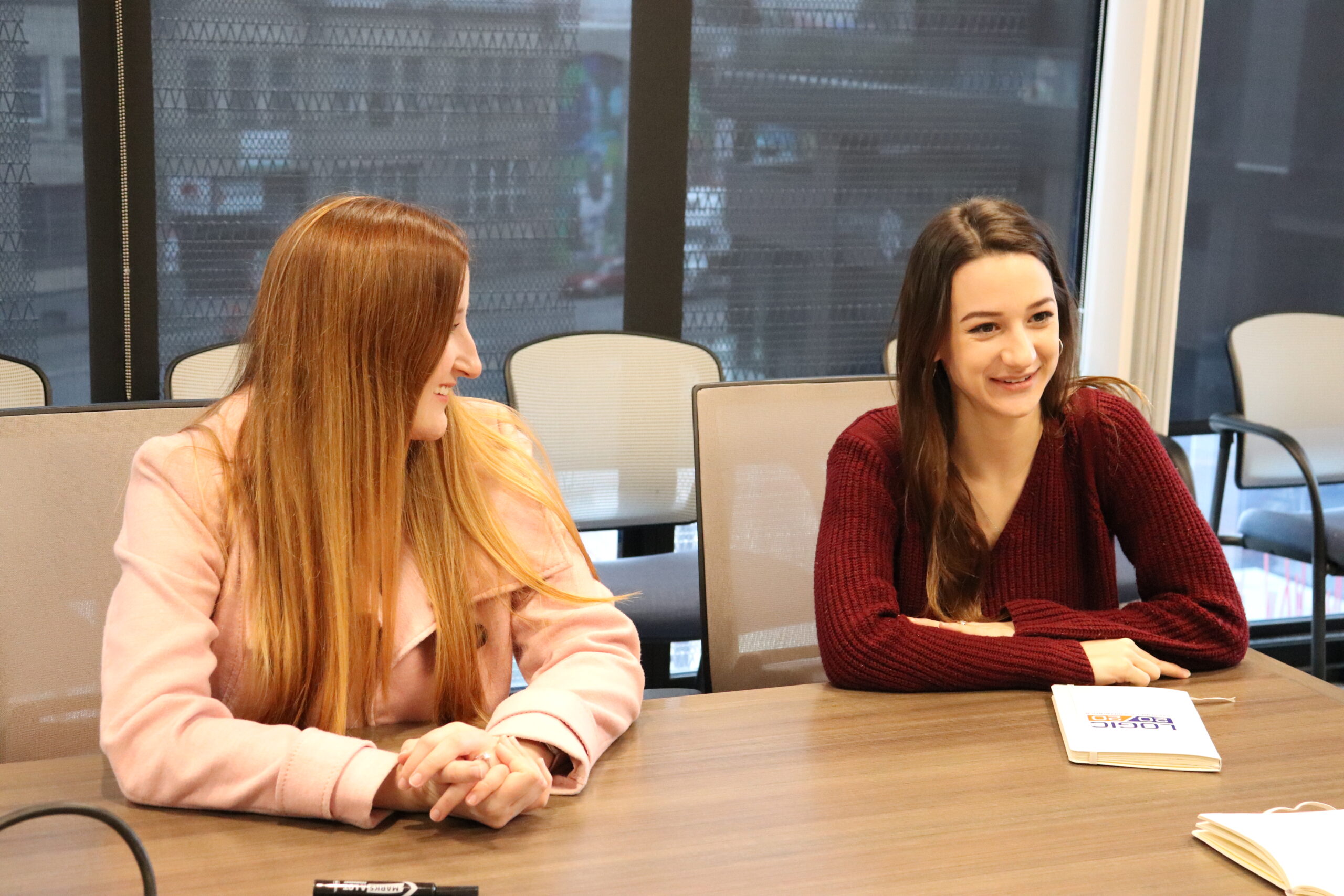 Two women sitting at conference table