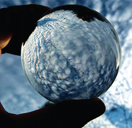 Hand holding marble in sky