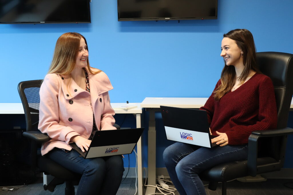 Two Logic20/20 teammates conversing in an office setting