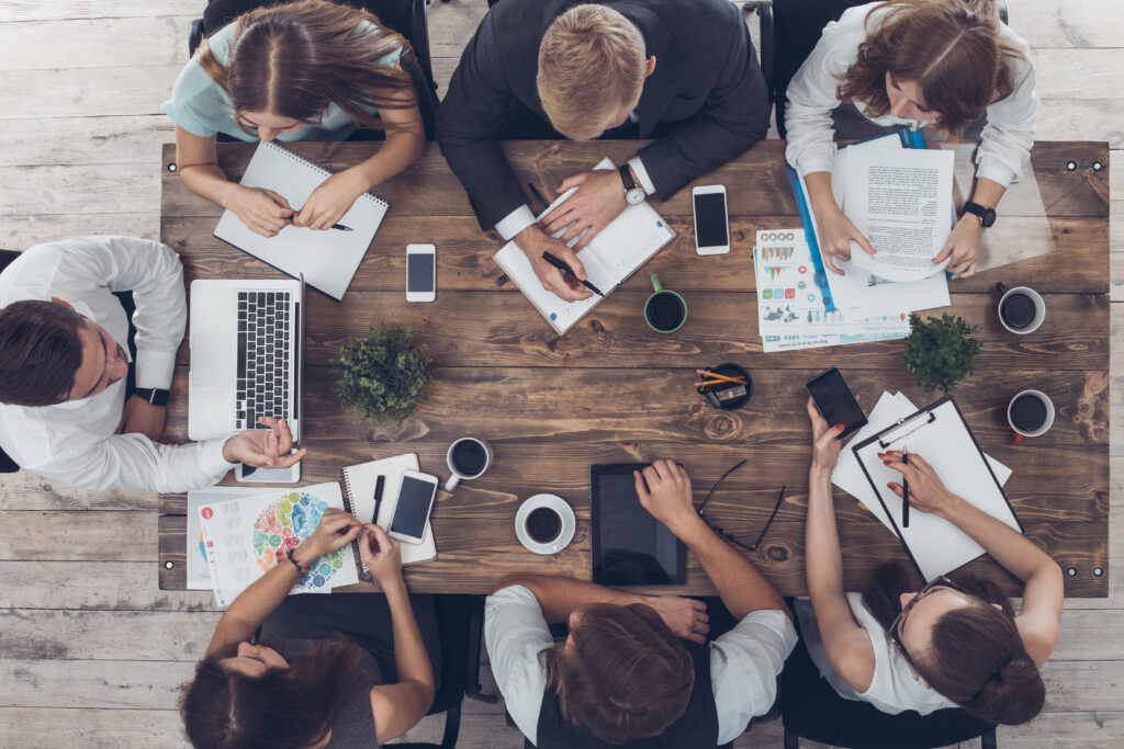 Business people man and women meeting in the office top view using digital device