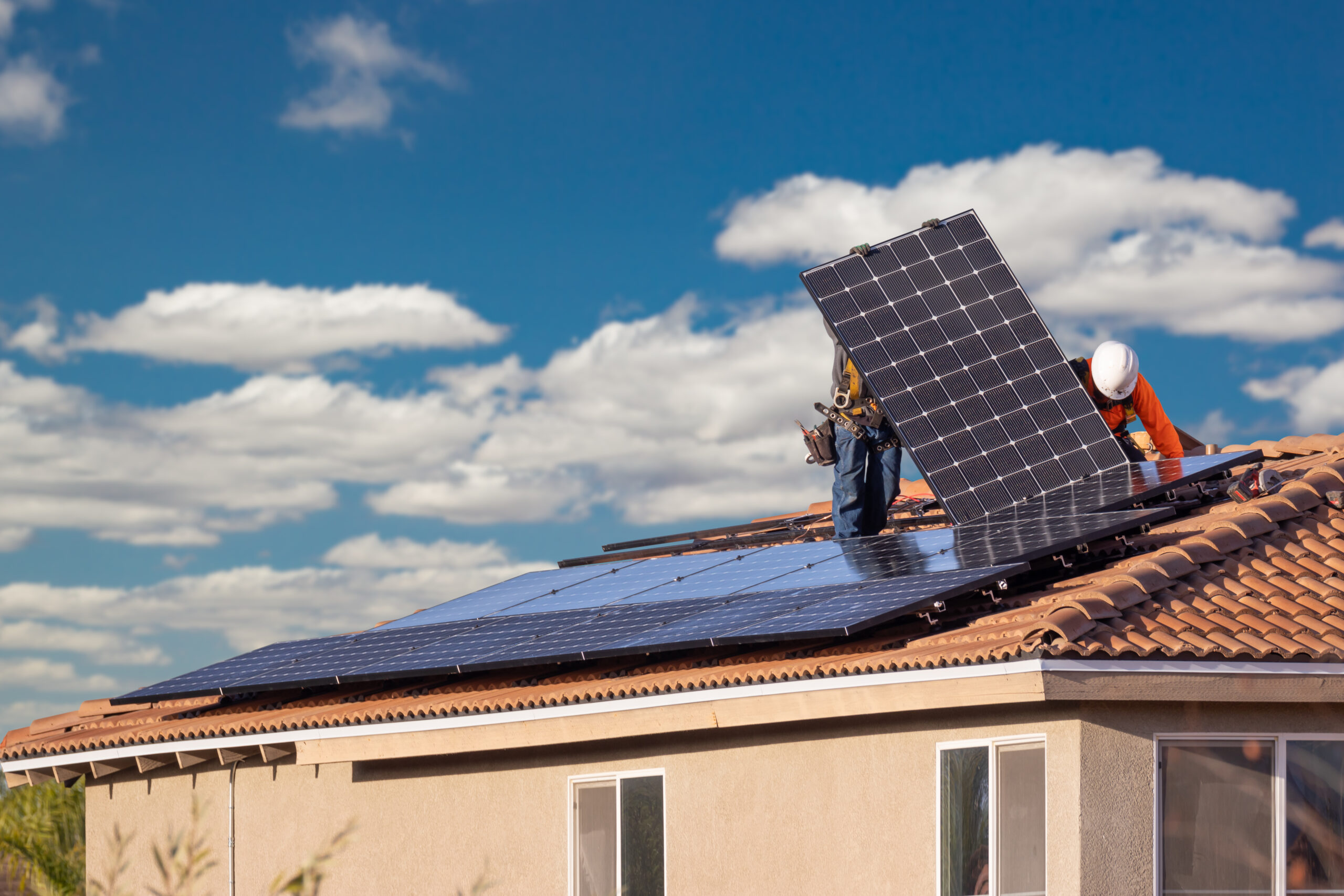 People installing solar panels on roof