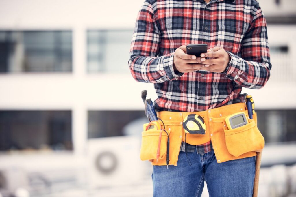 builder at a construction site using a smartphone