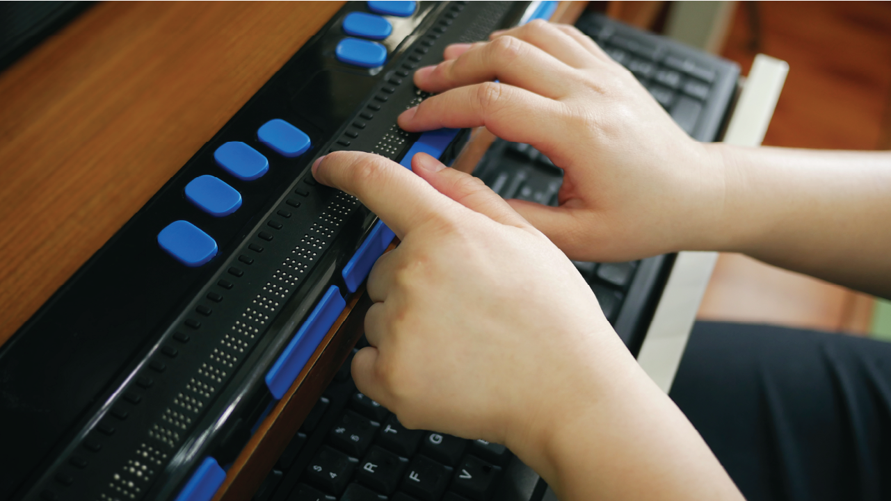 Close up of hands using braille keyboard