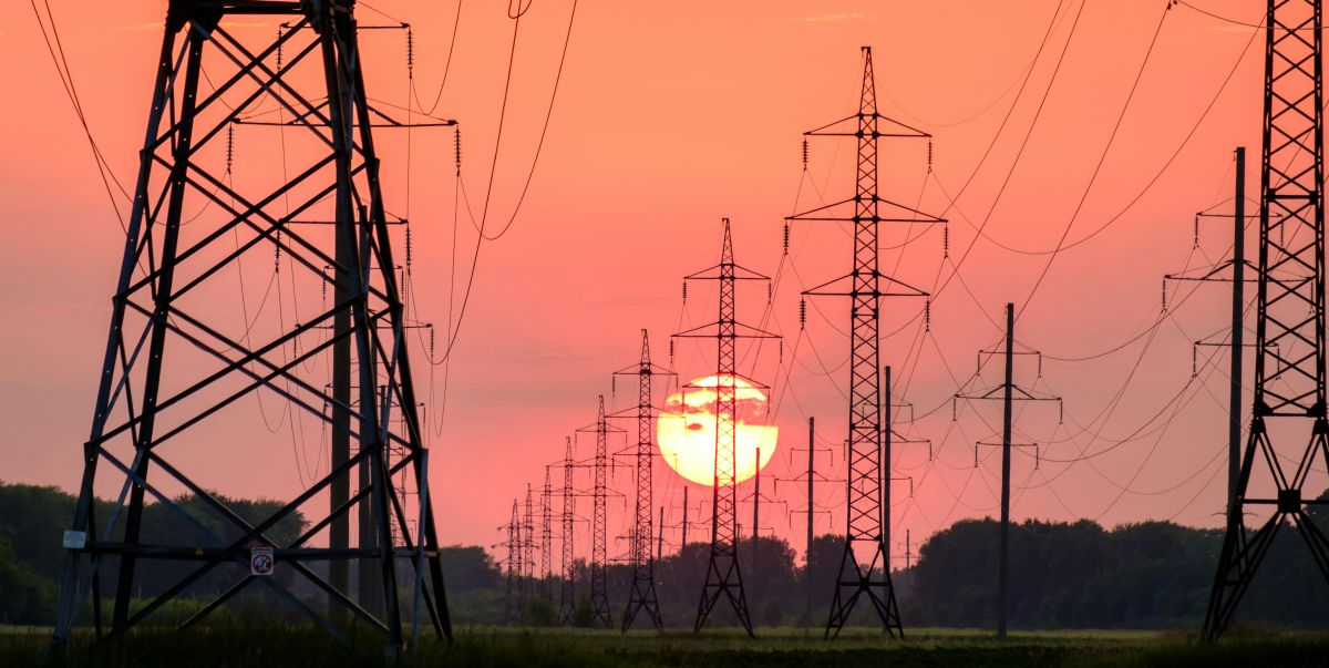 distribution power lines against a setting sun