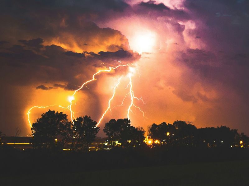lightning storm over trees at night