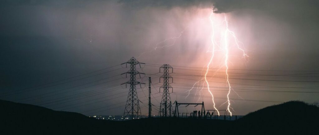 electricity distribution towers against the background of a lightning storm