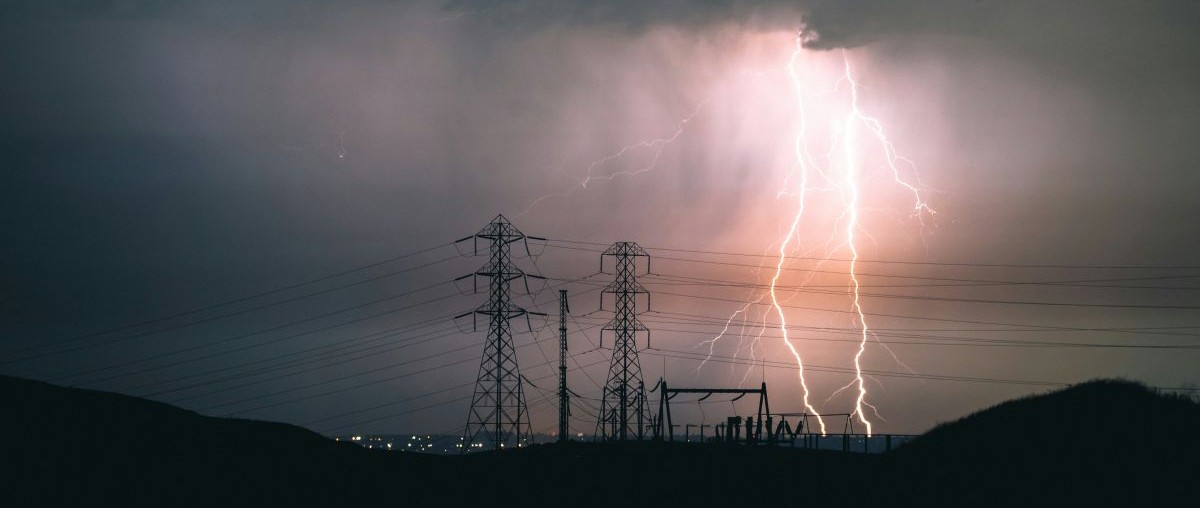 electricity distribution towers against the background of a lightning storm