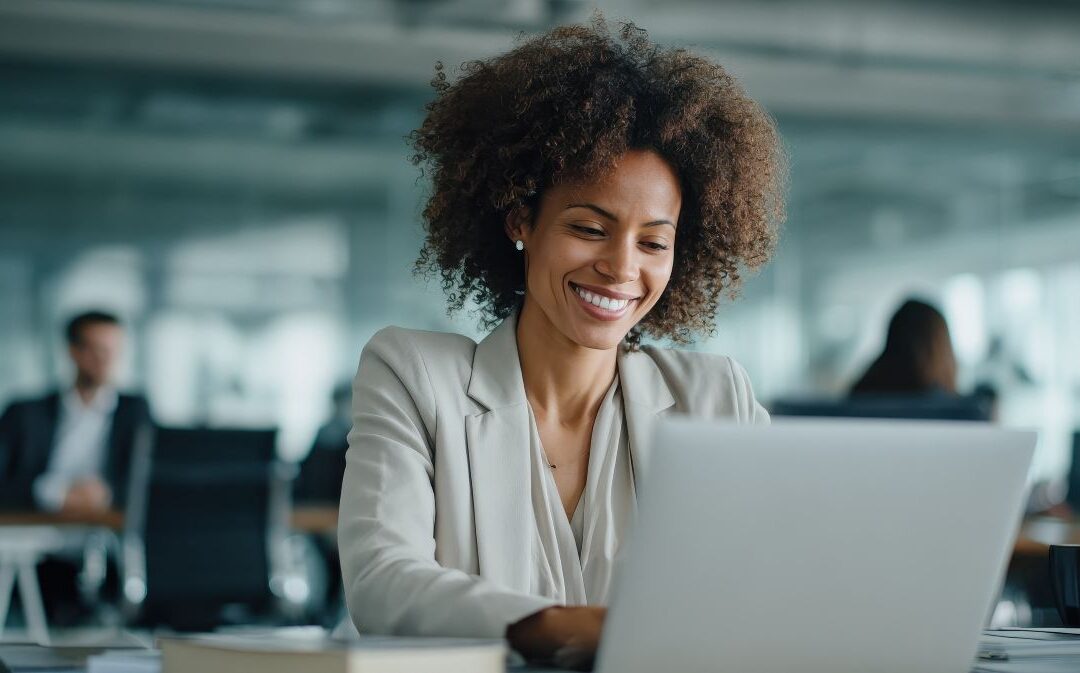 smiling woman working at a laptop computer in a modern office setting
