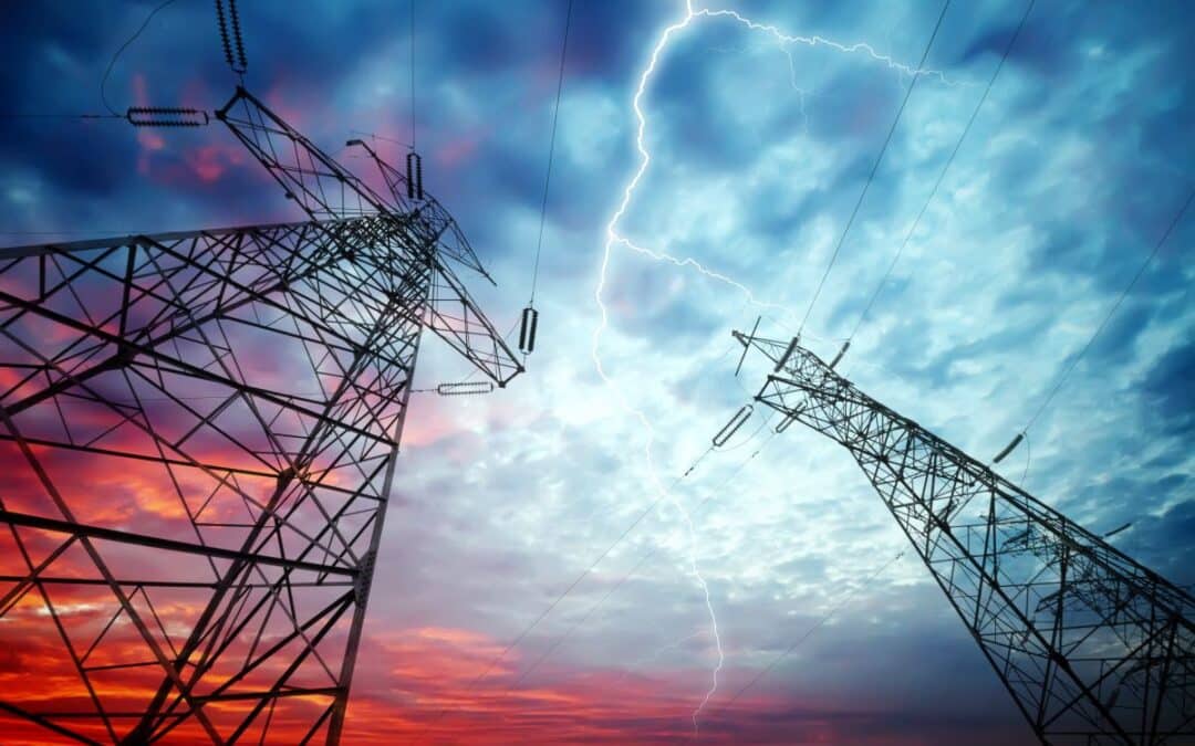 upward-facing view of two utility towers against a lightning-filled sky at dusk