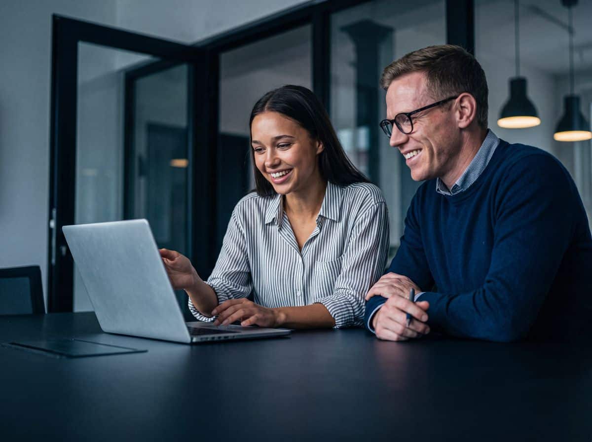 happy compliance team working with AI on a laptop computer