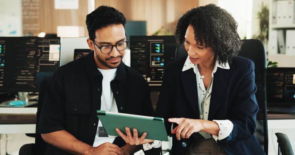 office workers collaborate around a tablet screen