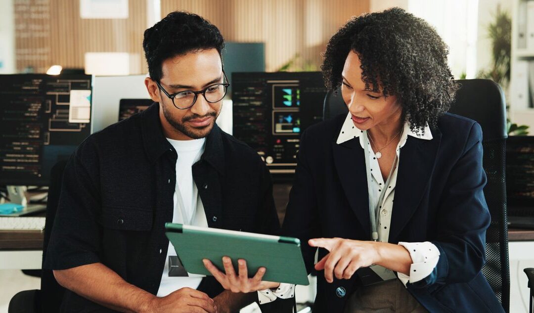 office workers collaborate around a tablet screen