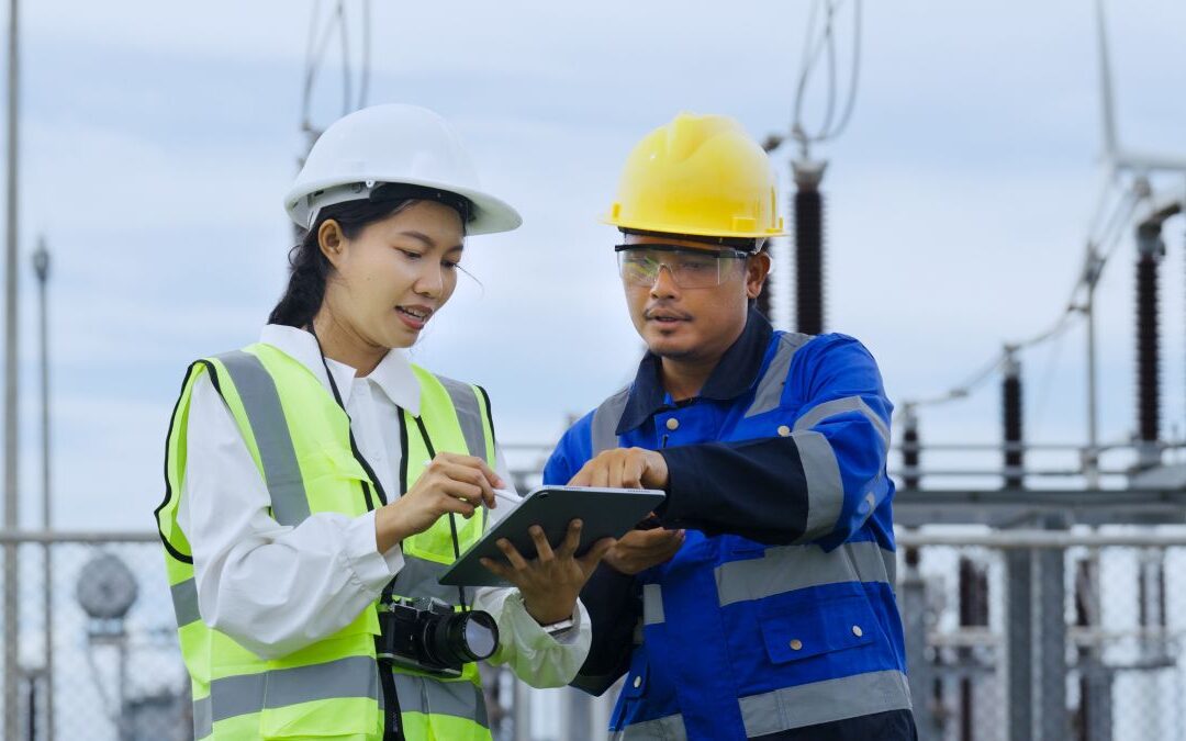 engineers reviewing data on a tablet at an electricity substation