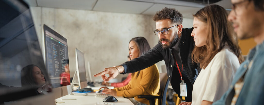 Man showing people something on a computer