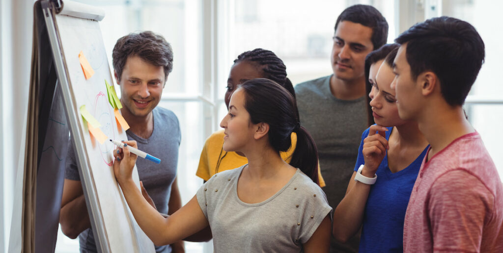 Group of people view white board